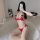 Woman wearing red lace bra and panty set, posing on white rug with phone covering face.