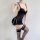 Woman modeling black sheer lace bodysuit with push-up bra and matching thong, featuring provocative uniform style design.