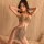Woman modeling qingran sexy lace bodysuit dress with sheer mesh, adjustable straps and sparkling details for nightclub wear.