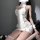 Woman wearing white qingran high-neck backless lace knit lingerie set with side cutouts and matching garter stockings.
