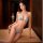 Woman modeling light blue qingran bikini set with butterfly hip tie and lingerie-style top on bed.