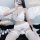 Woman wearing qingran lace bridal garter set with sheer chiffon thong and floral trim, posing with angel wings for sensual pr...