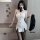 Woman wearing white qingruohan milk silk bodysuit, a sexy secretary uniform outfit with black stockings and holding a black j...