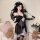 Woman modeling qingruohan sheer black lingerie set with lace robe, heart detail, and feather accessory in cozy bedroom settin...