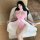 Woman in pink qingruohan silk qipao lingerie set with white sheer robe, seated on beige chair.