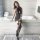 Woman wearing qingruohan sheer black lingerie set with hook-neck bodycon dress and thigh-high stockings in modern bathroom.