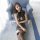 Woman wearing qingruohan sheer lingerie set with hook-neck bodycon dress and lace stockings, posing on blue armchair.