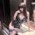 Woman wearing qingshe lace temptation lingerie set – elegant black lace bodysuit with blue floral garters, posing in mirror.
