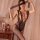 Woman wearing qingyegé sheer mesh bodystocking with lace details, holding a matching eye mask in a softly lit bedroom setting...