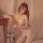 Woman in qingyegé sheer bodysuit with open-crotch design, posing beside wooden table with roses.