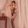 Woman modeling black qingyege lace bodysuit with sheer mesh, floral embroidery, and matching thigh-high stockings in soft bed...