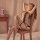 Woman wearing qingyege sheer mesh bodysuit with open-crotch design and matching stockings, seated on wooden chair in soft-lit...
