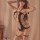Woman wearing qingyege sheer mesh bodysuit with open-crotch design and matching fishnet stockings, posing sensually indoors.