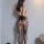 Woman wearing qingyege sheer mesh bodysuit with open-crotch design and matching lace-top stockings, back view.