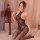 Woman wearing qingyege sexy lace bodysuit with open-crotch design, sheer mesh tight-fit one-piece outfit, kneeling on bed.
