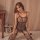 Woman wearing qingyege sexy lace bodysuit with sheer mesh pantyhose, european style one-piece outfit on bed.