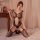 Woman modeling qingyege sexy lingerie set with sheer mesh stockings and open-crotch top, seductive uniform outfit on bed.