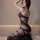 Woman wearing qingyege sheer black bodysuit with open-crotch design and matching stockings, elegant lingerie set.