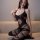 Woman wearing qingyege black sheer bodysuit with open-crotch design and matching stockings, elegant lingerie set.
