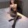 Woman wearing qingyege sheer lace bodysuit with fishnet stockings, posing seductively on bed in black mesh lingerie set.