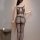 Woman wearing qingyeguo sheer mesh bodysuit with open-crotch design and matching stockings, back view.
