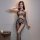 Woman wearing qingyeguo sheer mesh bodysuit with open-crotch design and matching stockings, posing on a bed.