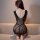 Woman wearing black mesh bodysuit with intricate lace detailing, seated on beige couch, showcasing back view of qingyeguo sex...