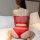 Woman wearing red qingyeguo sheer lace bodysuit set with mesh cut-outs, kneeling on bed.