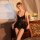 Woman wearing qinmu sexy lace lingerie set – sheer mesh cami and briefs, in elegant bedroom with vintage decor.