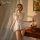 Woman modeling white qinmu sexy lace lingerie set with sheer mesh cami, briefs, and tulle skirt in candlelit room.