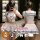 A woman wearing a white sailor-style top and skirt, taking a mirror selfie. the outfit features blue accents and appears to b...