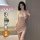 Woman modeling a shimmering rose gold qqny pure allure sleepwear set, an elegant and seductive lingerie piece designed for lu...