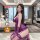 Woman modeling purple qqny pure allure sleepwear set in luxury bedroom, featuring lace lingerie and gloves for elegant sensua...