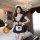 Model wearing qqny pure allure sleepwear set – black maid-style lingerie with lace trim, apron, and headpiece in luxurious be...