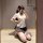 A woman poses in a mirror wearing a stylish white blouse with a bow tie, paired with a plaid skirt and lace stockings, showca...