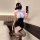 A woman poses in a black and white qqny pure allure sleepwear set, featuring elegant seductive design elements perfect for lu...