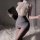 Woman in qqny pure & tempting lingerie set featuring lace top and pencil skirt, holding a tablet.