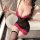 A woman poses in a luxurious bathroom, wearing a seductive black lace corset dress with pink accents and sheer fabric. the ou...