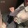 A person wearing a white blouse with a gray tie, paired with black shorts, showcasing a stylish and feminine schoolgirl outfi...