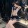A stylish young woman poses confidently wearing a chic schoolgirl-inspired outfit featuring a sailor-style top with a navy sk...