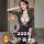 Woman modeling black lace qqny lingerie set with sheer sleeves and deep v-neck, paired with high-waist shorts — sensual, eleg...
