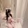 Woman in pink rabbit girl lingerie set with bunny ears, holding plush toy, kneeling on floor for role play.