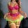 Woman wearing vibrant rainbow lace petticoat lingerie set with heart embroidery, sheer mesh skirt, and neon green garters.