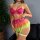 Woman modeling rainbow lace petticoat lingerie set with sheer mesh skirt, heart embroidery, and neon green garters.