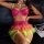 Woman wearing vibrant rainbow lace petticoat lingerie set with heart embroidery, sheer mesh skirt, and neon green straps.