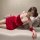 A woman poses on a couch wearing a red christmas deer print velvet lingerie set, featuring a sexy design perfect for sleepwea...