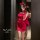 Woman wearing red christmas lingerie set with lace gloves and headband, posing in front of mirror.