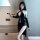 A woman poses elegantly in a black velvet dress with lace detailing, featuring a split-back design and deep cutouts, embodyin...