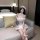 A woman sits on a couch wearing a maid-themed bodysuit set featuring lace details, sheer mesh elements, and fishnet stockings...