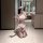 A woman poses playfully in a bathroom, wearing a maid-themed outfit featuring a lace bodysuit, sheer mesh stockings, and a ma...